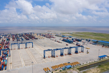 Aerial view, top view cargo ship port in the export, import by ship business, and logistics international goods. Logistics and transportation of container cargo ship working crane bridge in shipyard