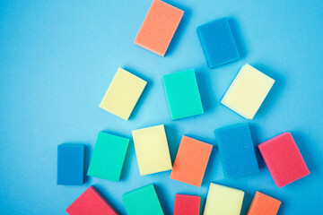 Fototapeta na wymiar New colorful sponges for washing dishes on blue background
