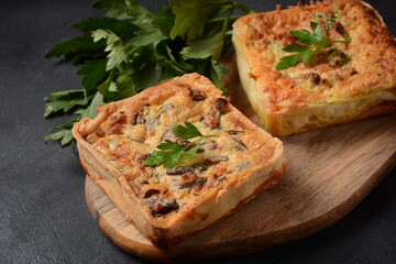 Homemade quiche or pie with  broccoli, seasonings, champignons and cheese on a gray background.