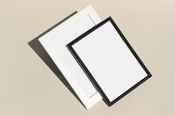 Empty black and white picture frames with white background copy space on beige background