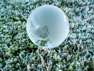 Glaskugel Erdball auf einer Wiese mit Frost