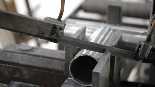 welded seam on a section of a steel pipe with the help of a grinding machine in the metal workshop