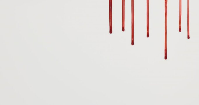 Red blood liquid dripping down on white background.