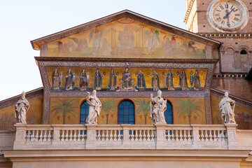 Fototapeta na wymiar Facade of Santa Maria Our Lady in Trastevere with sculpted statues of popes and apostles, gilded mosaics in touristic Trastevere neighbourhood in Rome, Italy