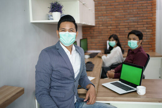 Portrait Of Coworkers Who Are Busy Working According To Their Respective Places. In The Office With Mask For Healthy