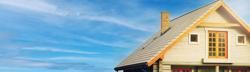 modern log cabin against blue sky. banner copy space