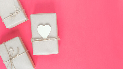 gifts in eco-friendly craft packaging for the holiday on a pink background