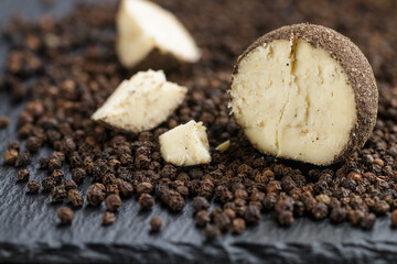 Belper knolle - hard Swiss cheese in the form of small balls sprinkled with black pepper Cut in half. Gourmet appetizer Close-up. Selective focus and shallow depth of field