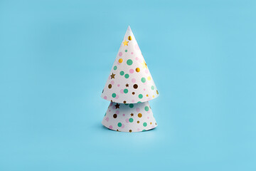 Minimalistic Christmas tree made of Colorful Hats for Party. New year simple composition. Merry Christmas and happy New Year greeting card.