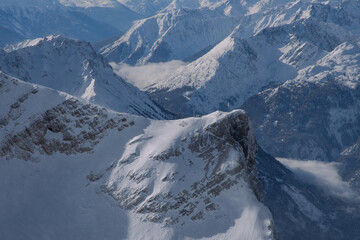 Fototapeta na wymiar Snow-covered mountains in the Alps in winter, seen from the Zugspitze mountain peak