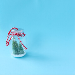 Creative concept holiday celebration photo of christmas tree in glass bottle decoration on blue background.