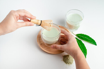 Girl holding mug of Matcha green Tea in her hands. Organic green tea leaf isolated on white background, Organic product from the nature for healthy with traditional style