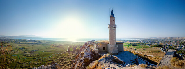 Sunset over castle of Van and Van lake with a minaret. Van castle on sunset. Fortress built during...