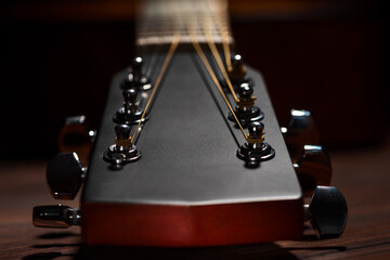 Close-up acoustic guitar on wooden background.