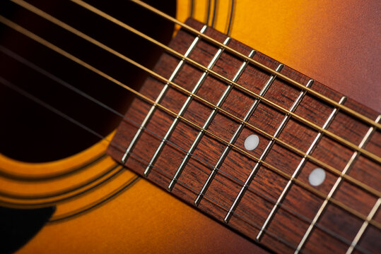 Close-up acoustic guitar on wooden background.