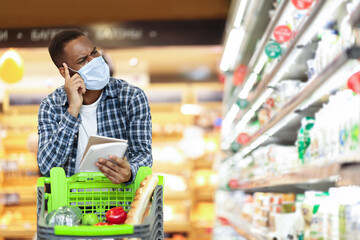 African Husband In Mask Shopping Grocery With Checklist In Supermarket