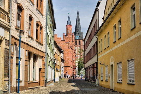 bitterfeld, deutschland - altstadtgasse mit rathaus und kirche st. antonius im hintergrund