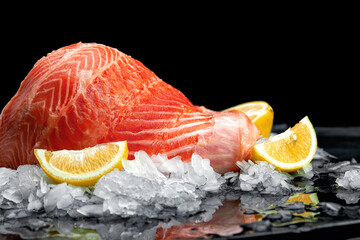 Fresh raw salmon fish steak on ice over dark stone background. Creative layout made of fish, top view, flat lay