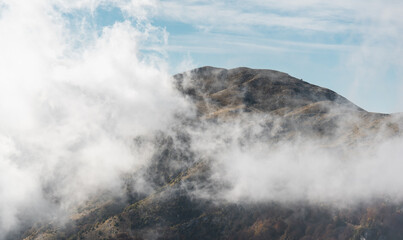 Fototapeta na wymiar White clouds wrap around spectacular mountain Paggaio. Greece