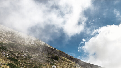 Scenic landscape view with mountain slope in low lying cloud