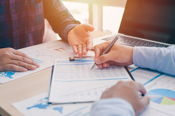 The teamwork of business people analysis cost graph and Idea presentation, analyze plans on the desk at the meeting room