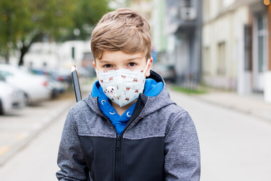 Portrait of a boy with protective face mask on city street.