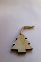 Wooden ornament shaped like Christmas tree on lilac background. Selective focus.