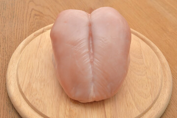 raw chicken breast on a wooden cutting board, white meat for making delicious, healthy homemade soup and meal