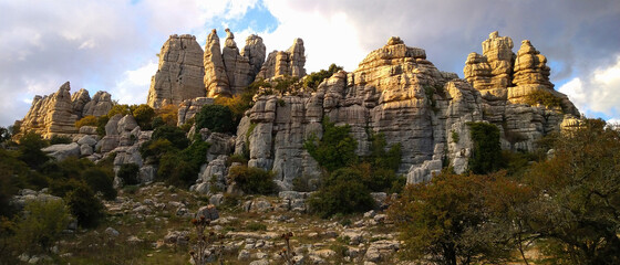 Panorama view of the impressive stone formations in the beautiful karst landscape of El Torcal de Antequera at sunset with blue sky, Spain
