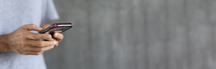 Man using smartphone against grey wall background with copy space, Concept people use technology