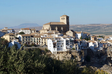 Panorama view of the historic city center with the Church of Incarnation in Alhama de Granada, Spain, Europe, in front of fields with olive trees
