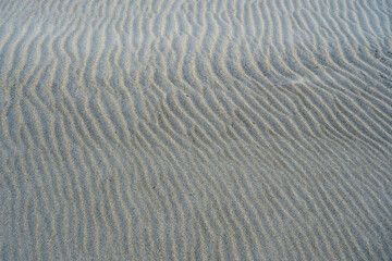 Close-up / background of the pattern of regular lines in the sand at low tide