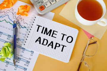Business concept - notebook writing TIME TO ADAPT
