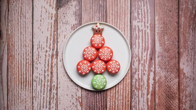 Christmas decorated macarons coming into frame and forming a Christmas tree with a gingerbread star tree topper.  4k stop motion animation
