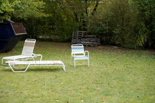 View of three shezlong chairs placed in the backyard of a house on a spring day