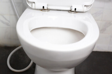 Modern bathroom ceramic toilet bowl with black background.