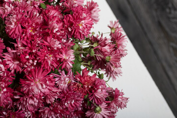 Bouquet of red chrysanthemums on a white table surface.