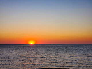 Obraz premium combination of Sunset and Beach. colorful orange sunset at the beach.