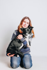 Young white woman hugs her border collie puppy. Isolated on white background. Studio portrait. Owner and her dog posing together.