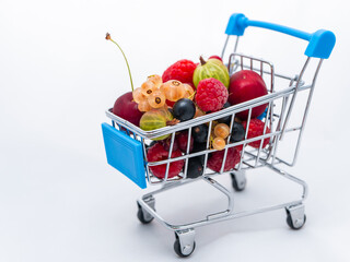 Mini grocery cart filled with fresh vitamin berries isolated on white background
