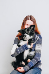 Young white woman hugs her border collie puppy. Isolated on white background. Studio portrait. Owner and her dog posing together.