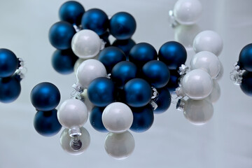 Blue and white small Christmas balls on a mirror