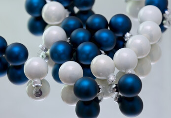 Blue and white small Christmas balls on a mirror
