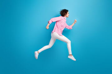 Fototapeta na wymiar Full length photo of cheerful lady jump run fast copyspace isolated over blue pastel color background