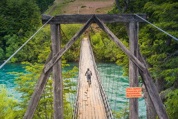 Cyclist by the wooden bridge at Futaleufu, Patagonia -
Chile.