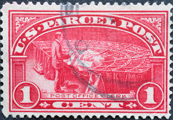 USA - Circa 1912 : a postage stamp printed in the US showing a post office clerk sorts mail. Text: US Parcel Post