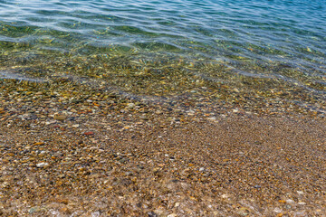Calm clear sea on a pebble beach 