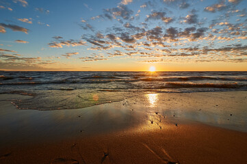Fototapeta na wymiar sunset on the sandy beach of the gulf of finland