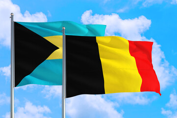 Belgium and Bahamas national flag waving in the windy deep blue sky. Diplomacy and international relations concept.