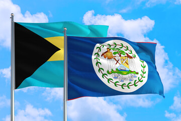 Belize and Bahamas national flag waving in the windy deep blue sky. Diplomacy and international relations concept.